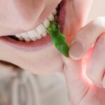 cheerful woman biting sweet green marmalade