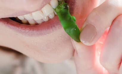cheerful woman biting sweet green marmalade