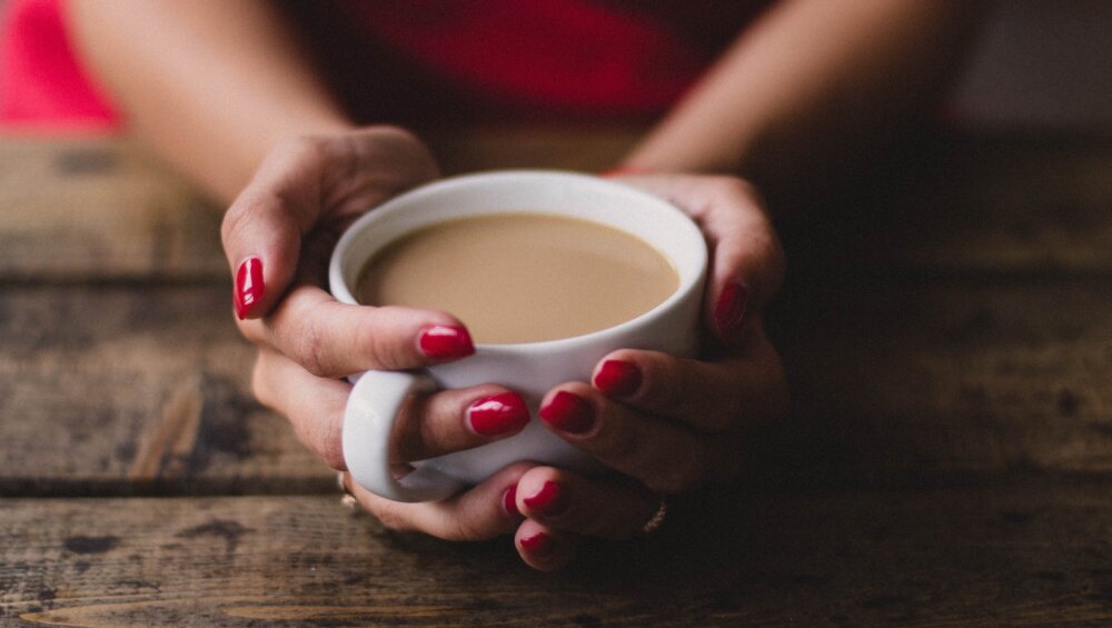 women holding cup of coffee