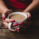 women holding cup of coffee