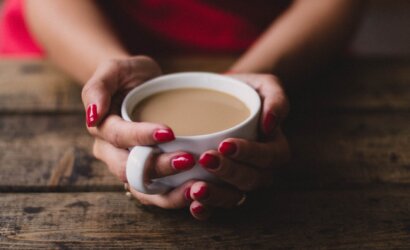 women holding cup of coffee