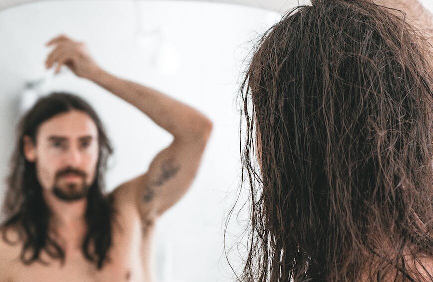 a man applying cosmetic product on hair with a dropper