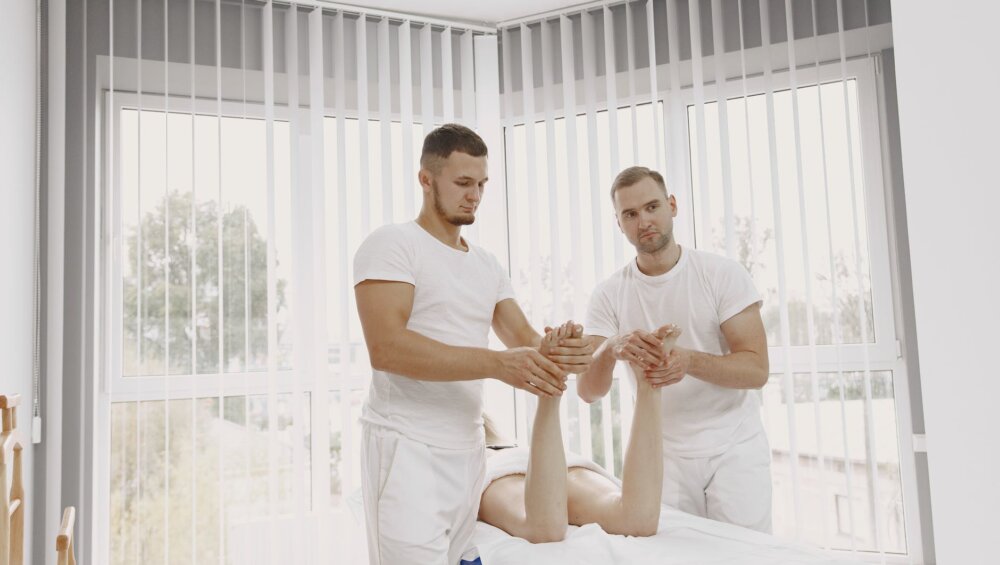 men in white shirts massaging a person s feet