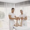 men in white shirts massaging a person s feet