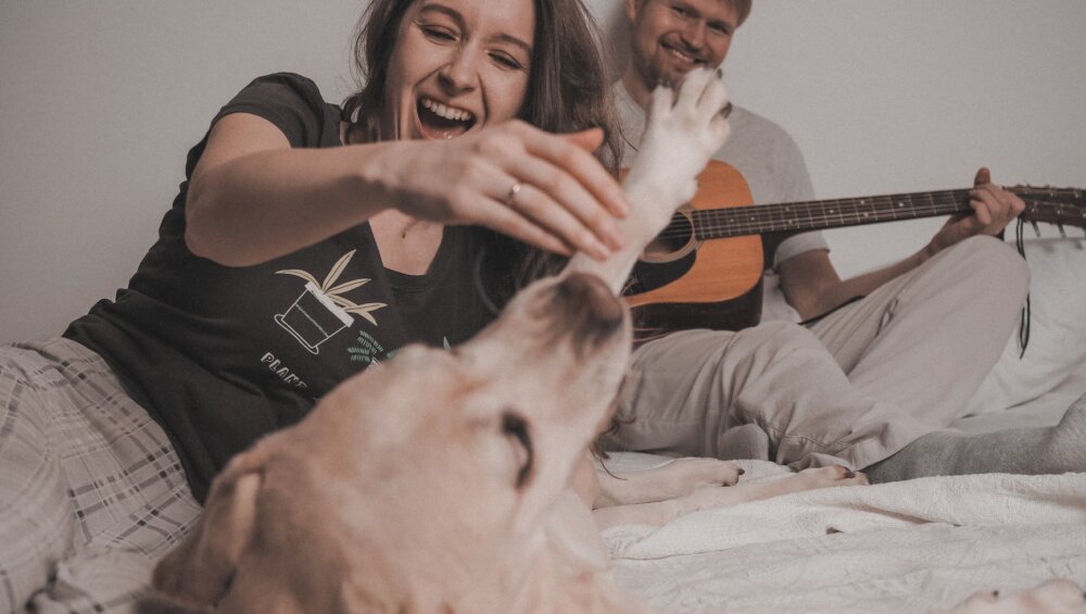 man and woman playing with dog