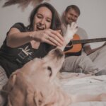 man and woman playing with dog