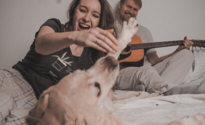 man and woman playing with dog