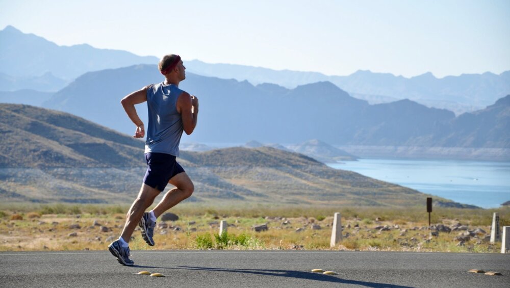 man running on side of road