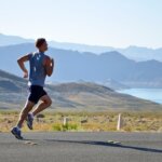 man running on side of road