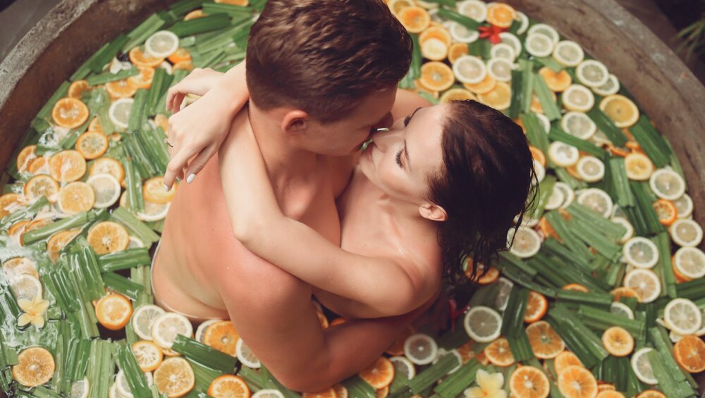 sensual couple hugging and kissing in stone fruit bath