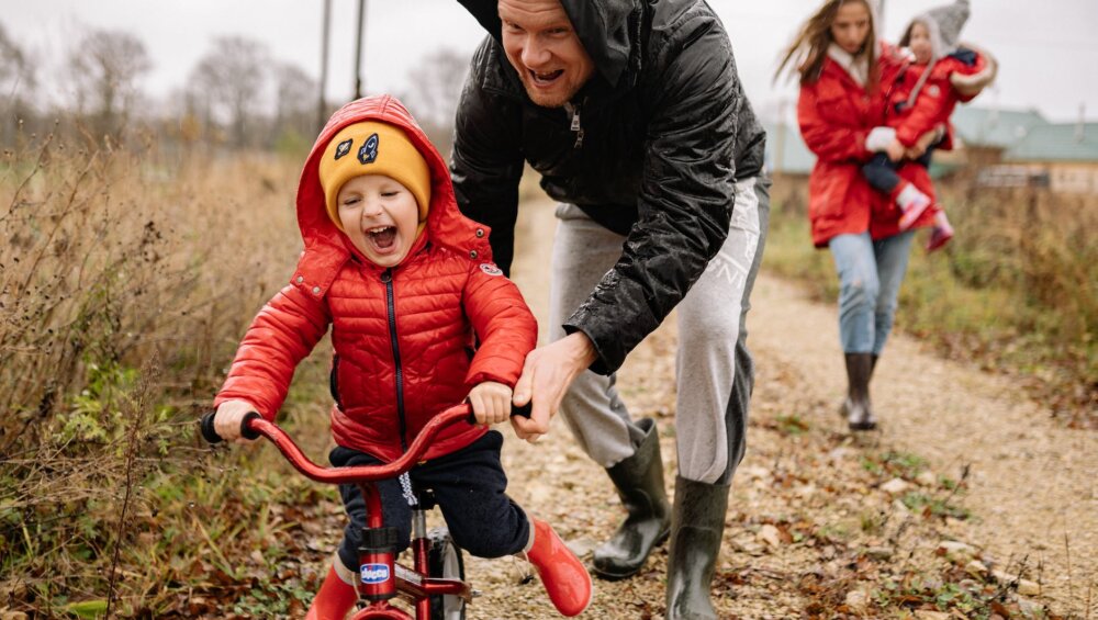 father teaching his son how to ride a bike