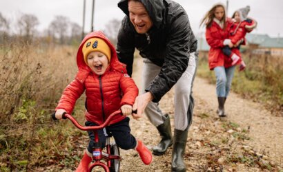 father teaching his son how to ride a bike