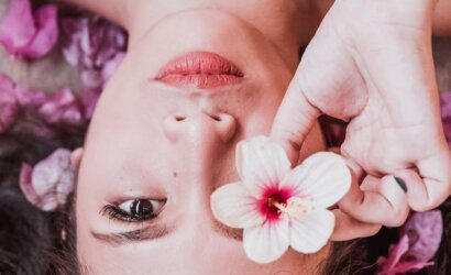 photo of woman holding pink flower