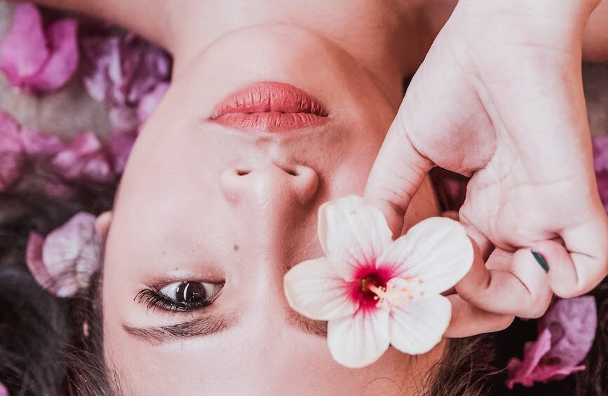photo of woman holding pink flower