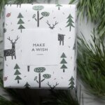 wrapped new year present box placed among coniferous branches