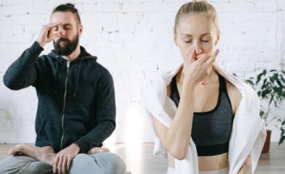 a man and a woman meditating practicing breathing control