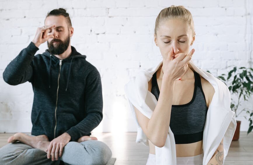 a man and a woman meditating practicing breathing control