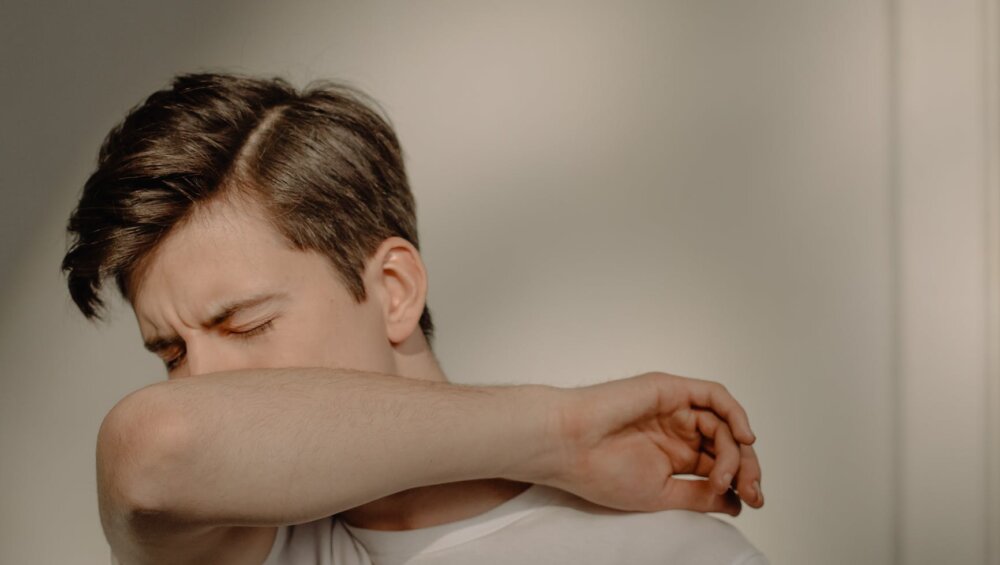 a sick man covering his mouth